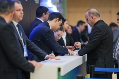 Kayıt masasında görevlilerin yanında evrak imzalayan delegeler